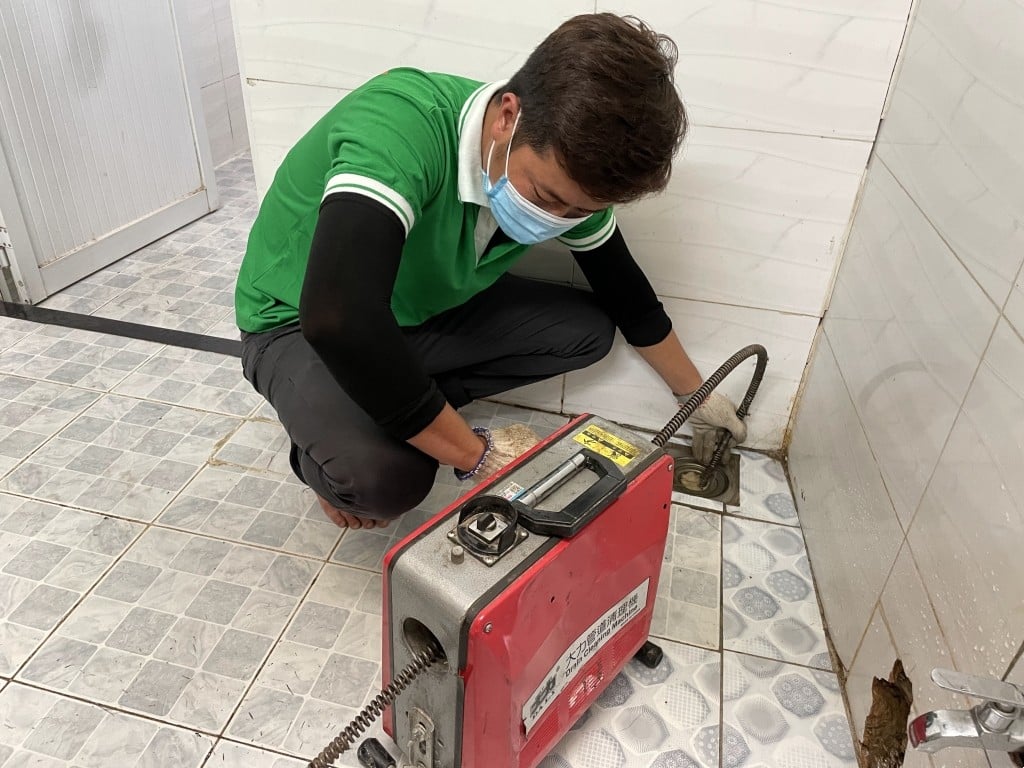 Nhân viên Dịch Vụ Vệ Sinh Môi Trường đang thông cống ngầm